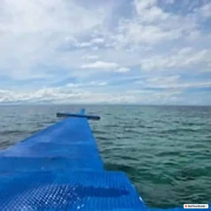 Long white sandbar extending into turquoise sea at Nalusuan with clear sky